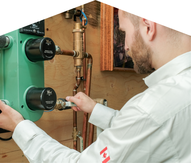 669 Heat HVAC specialist performing boiler installation, securing a valve on a new hydronic heating system with copper piping and a green circulation pump mounted on a wooden wall. 669 Heat HVAC specialist performing boiler installation, securing a valve on a new hydronic heating system with copper piping and a green circulation pump mounted on a wooden wall.