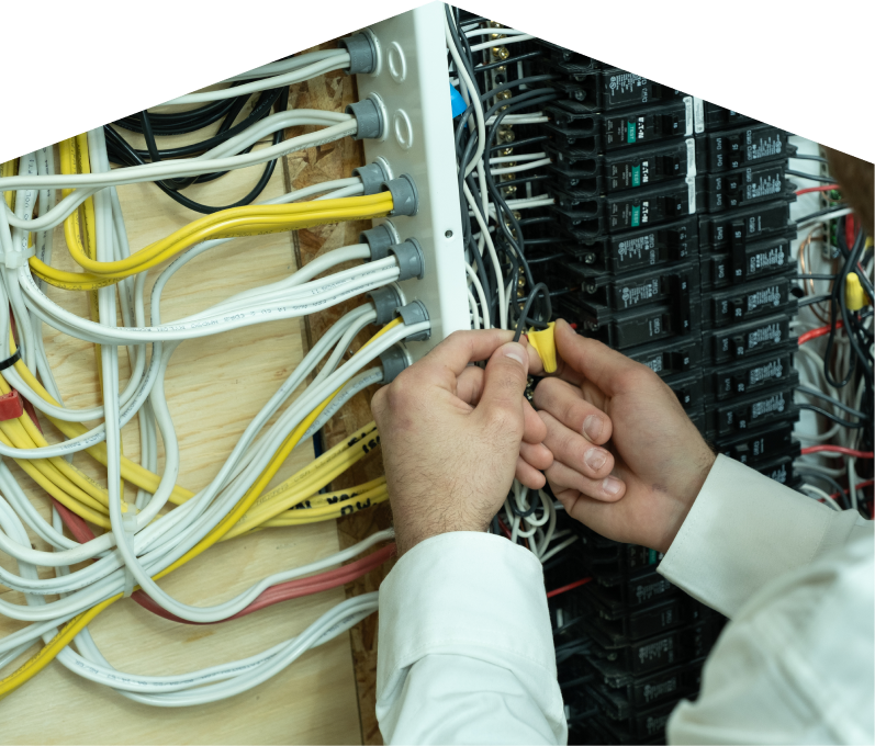 669 Heat service personnel working on electrical installations, connecting wires inside a residential breaker panel with neatly arranged colored cables on a plywood backing. 669 Heat service personnel working on electrical installations, connecting wires inside a residential breaker panel with neatly arranged colored cables on a plywood backing.