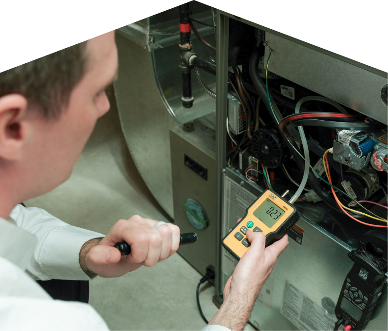 669 Heat HVAC specialist performing furnace repair on a heating system, using a digital manometer to check pressure. 669 Heat HVAC specialist performing furnace repair on a heating sy