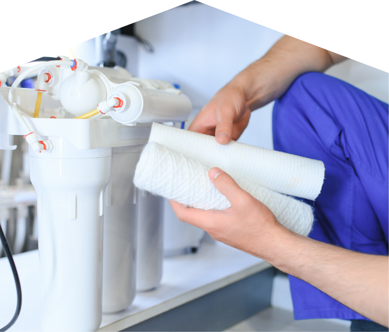 669 Heat water filtration specialist replacing filter cartridges on a reverse osmosis water system installed under a sink.