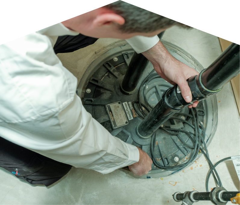 669 Heat sump pump specialist secures discharge piping on a sealed basin during a sump pump installation in a basement utility area. 669 Heat sump pump specialist secures discharge piping on a sealed basin during a sump pump installation in a basement utility area.