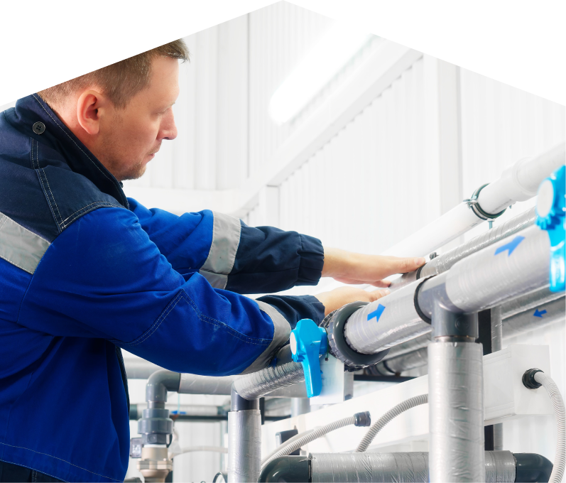 669 Heat water damage and restoration specialist in a blue uniform adjusts insulated piping on a water system inside a bright utility room. 669 Heat water damage and restoration specialist in a blue uniform adjusts insulated piping on a water system inside a bright utility room.