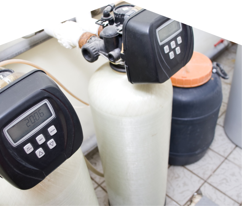 669 Heat water softener installation showing dual resin tanks with digital control heads and a brine tank in a tiled utility area. 669 Heat water softener installation showing dual resin tanks with digital control heads and a brine tank in a tiled utility area.
