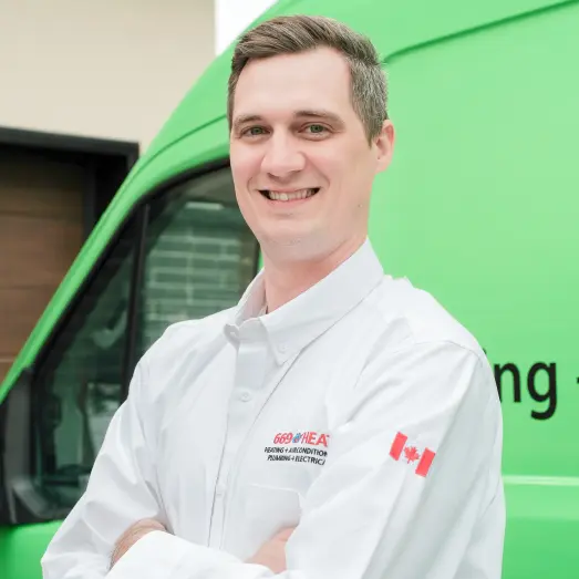 669-individual Smiling 669 Heat technician standing confidently in front of their green service van, wearing their white issued uniform.