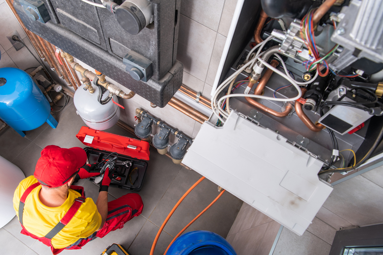 Residential Heating Systems Technician Performing Maintenance Residential Heating Systems Technician Performing Maintenance
