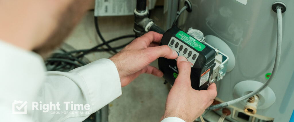 Technician checking the gas control valve and thermostat on a tank water heater.